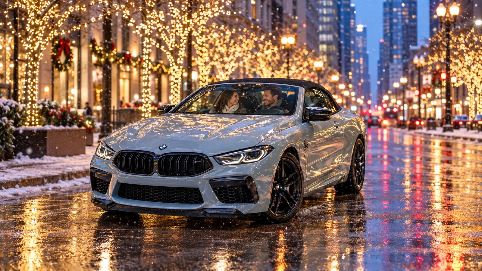 A couple in a silver BMW M8 convertible on Michigan Avenue among holiday lights and light snow